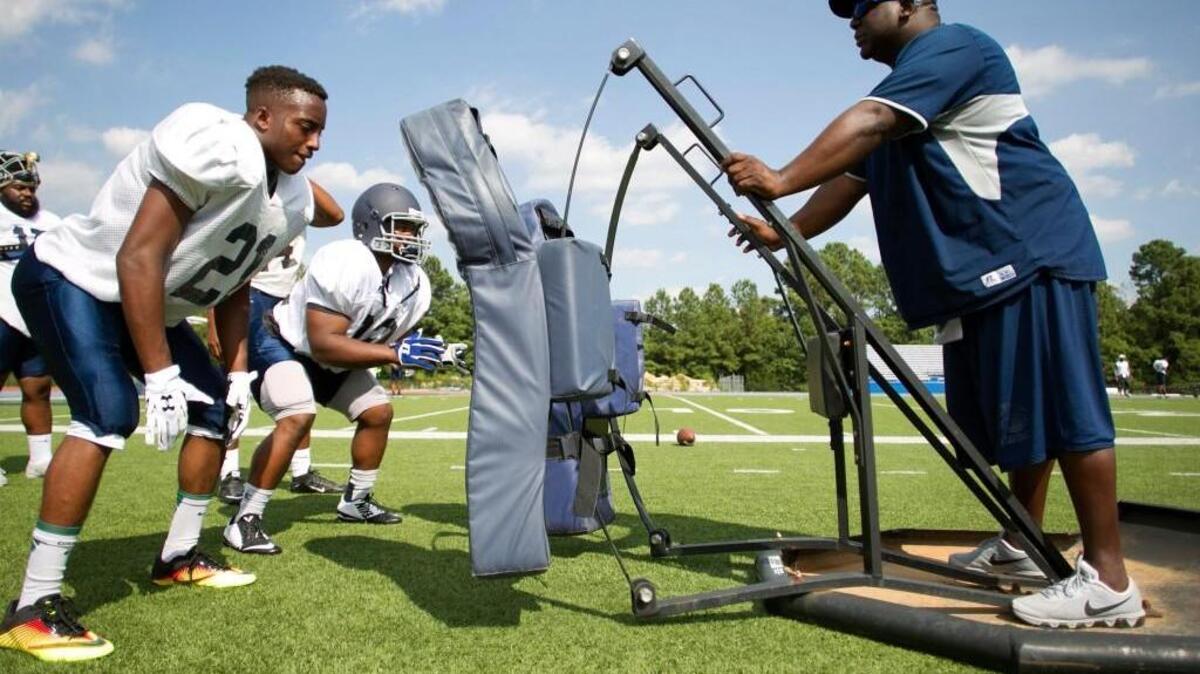 St. Augustine’s University coach Tim Chavous works with his players during practice on Thursday, August 25, 2016 in Raleigh, N.C.