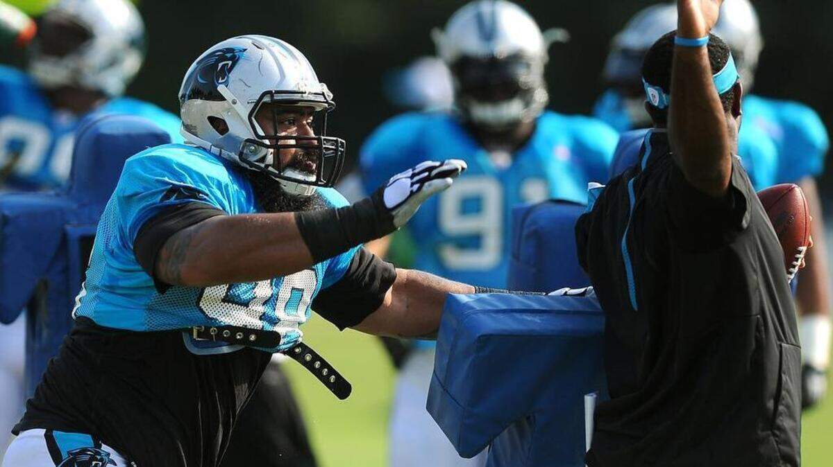 
Carolina Panthers Star Lotulelei, left, makes a swipe at a ball held by Sam Mills III, right, during practice on Monday. Lotulelei later left practice with what head coach Ron Rivera described as soreness in his surgically repaired right foot. 

