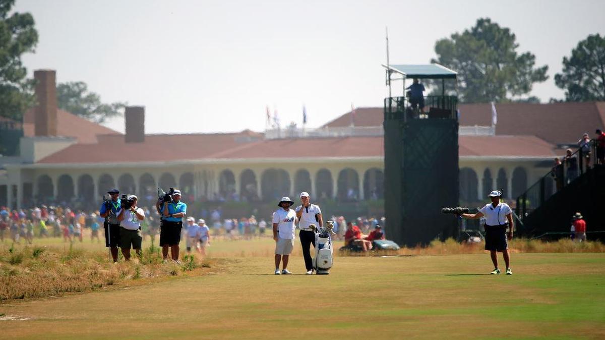 
With the Pinehurst clubhouse behind them, Martin Kaymer, right center, and his caddie Craig Connelly ponder a club selection on the second hole during the final round of the U.S. Open at Pinehurst No. 2 on Sunday, June 15, 2014.
