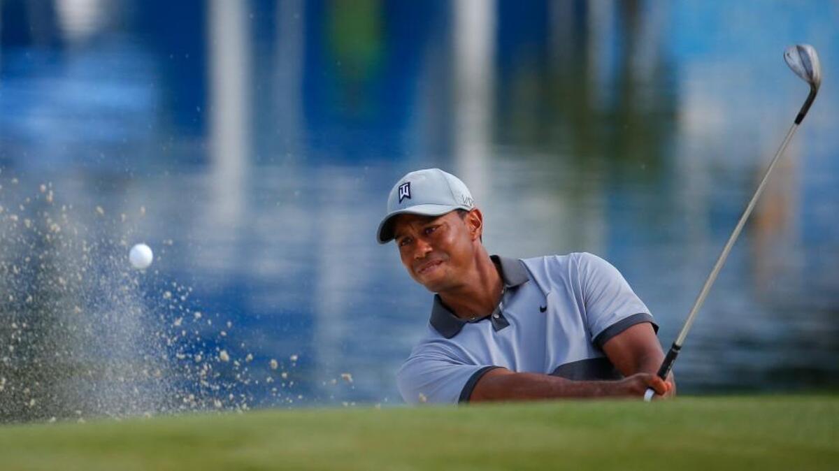
Tiger Woods chips out of the bunker on the 15th green during the third round of the Wyndham Championship at Sedgefield Country Club on Saturday in Greensboro.
