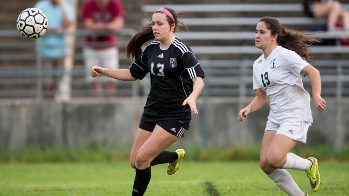 Wakefield's Caroline Wright (13) and Enloe's Gigi Cloney (19) run toward the ball during a high school soccer game in Raleigh, N.C. on Wednesday, Mar. 16, 2016.