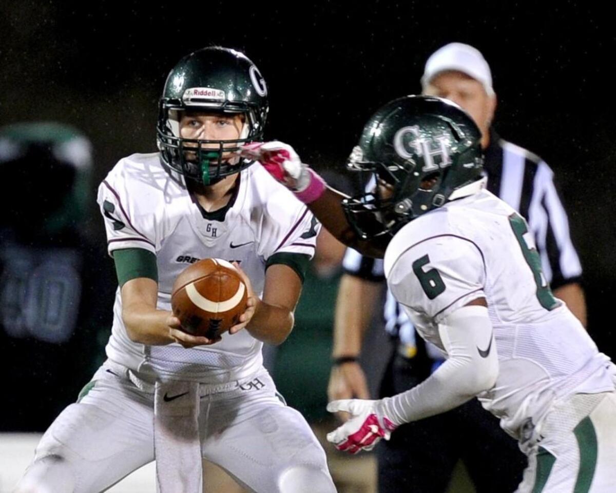 Green Hope quarterback Willie Taylor (left) hands off to Dylon Washington during the 'Fight for 55' football game, which was played in Cary on Thursday, October 6, 2016. Panther Creek won 28-27.
