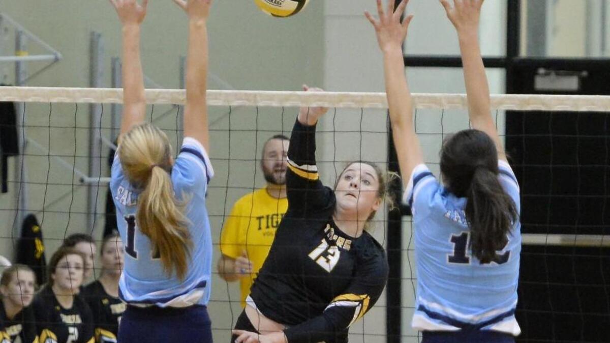 Kyra Crider (13) of Chapel Hill spikes the ball between Daelyn Brock, left, and Victoria Patnaude, right, of Aycock. The Chapel Hill Tigers played the C.B. Aycock Golden Falcons in a volleyball game that took place in Chapel Hill, N.C. on Saturday, October 29, 2016. Chapel Hill won 3-0.