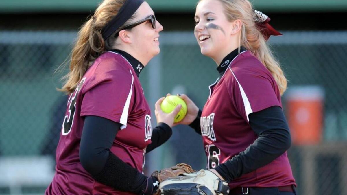 Cedar Ridge's Kaleigh Ragan (left) and Rivers Andrews (16) celebrate an out against Cardinal Gibbons during the girls softball game, which was played on Monday, March 21, 2016. Cedar Ridge won 15-0.
