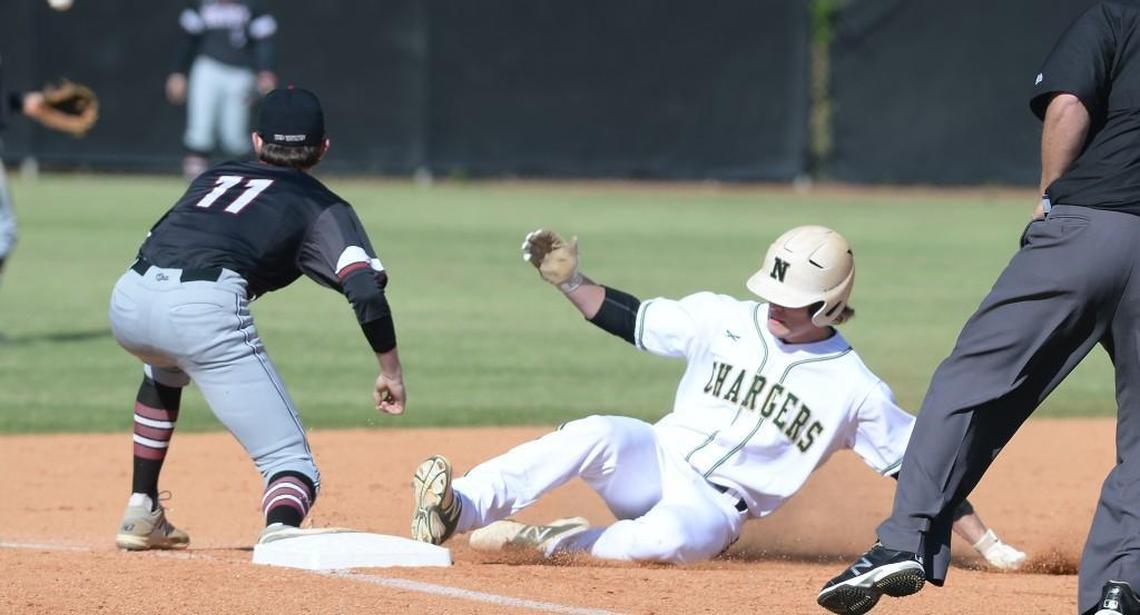 Max Hundley, center, of Northwood slides to the third base against Phillip Berger (11) of Cedar Ridge. The Northwood Chargers played the Cedar Ridge Red Wolves in a baseball game that took place in Chapel Hill, N.C. on Friday, April 7 2017. Northwood won 9-2.