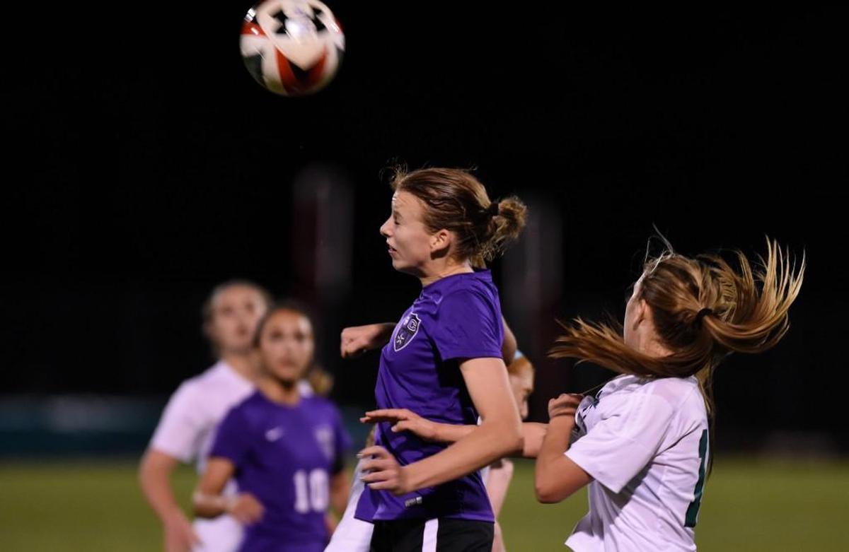 Carrboro's Natasha Turner (8) heads the ball alongside Leesville Road's Katie Groff (15) in Raleigh, N.C. on Wednesday, March 8, 2017. Leesville Road won 3-0.