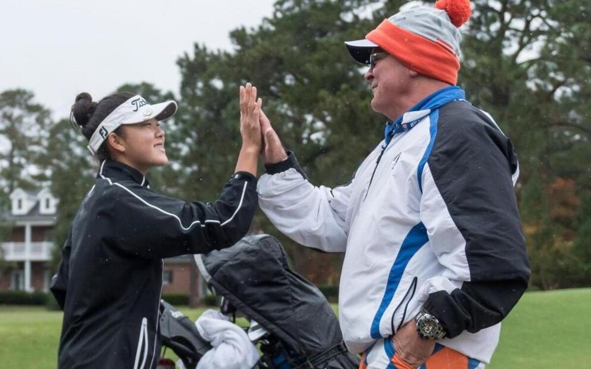 Jennifer Chang of Athens Drive celebrates with coach Dave Snyder after posting a two day total of 150 to win the 2015 NCHSAA 4A girls golf championship at Pinehurst No. 6 on Tuesday, October 27.