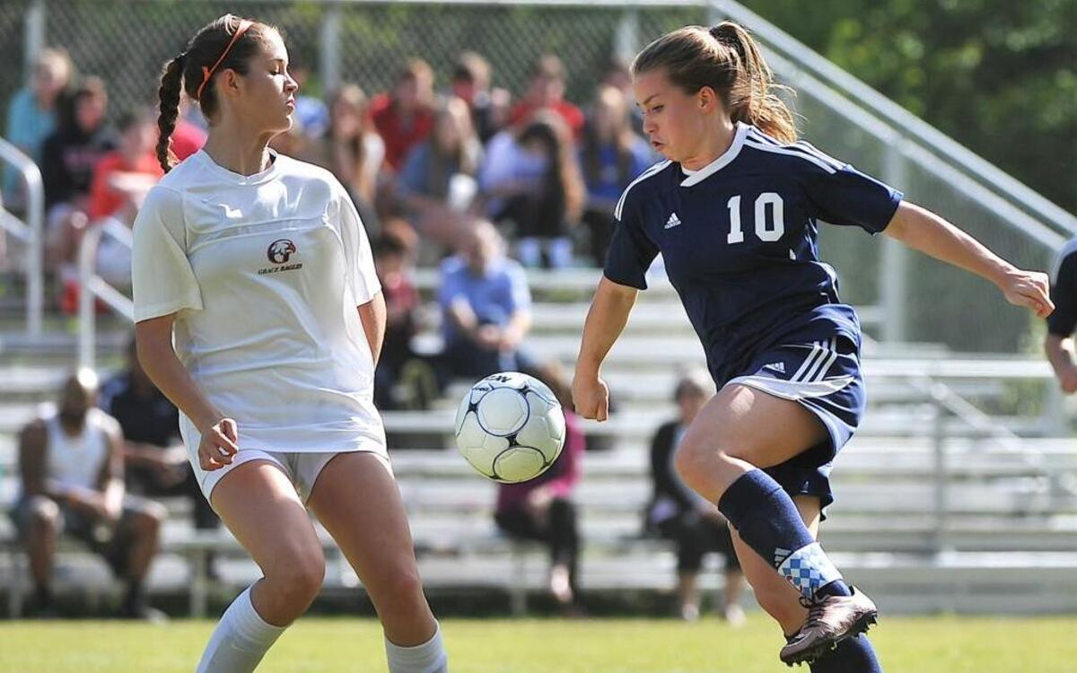Cary Christian's MaKenna Lagaly (10) controls the high ball while defended by Grace Christian's Micah King (17). Grace Christian took on Cary Christian Academy in soccer in Raleigh on April 15, 2016. Cary Christian won 3-1.