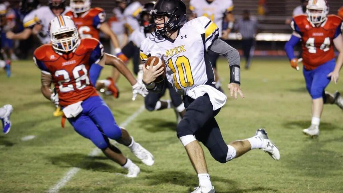 
Apex quarterback Grayson Boyd (10) runs outside for a big gain during Apex's football game at Athens Drive on Friday, September 11, 2015.
