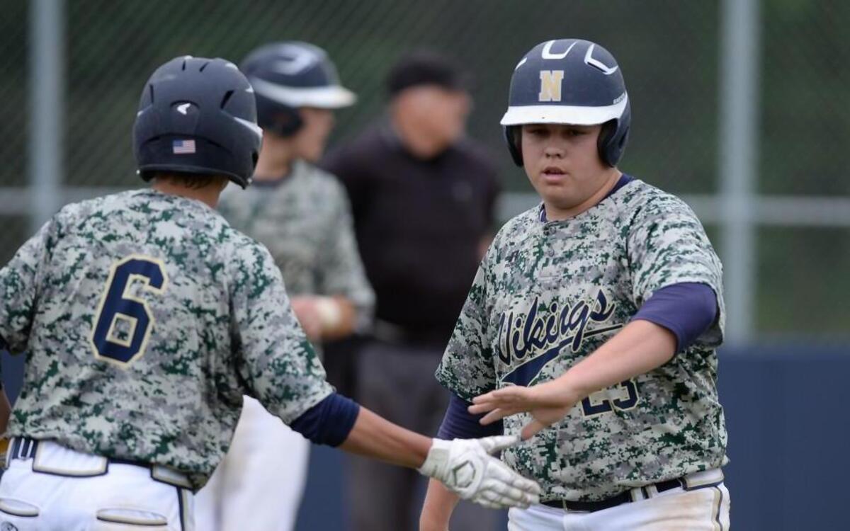 Austin Murphy (23) of Northern Vance is congratulated by his teammate Ryan Stainback (6) after scoring for the Vikings. The Northern Vance Vikings played the Southern Vance Raiders in a baseball game that took place in Henderson, N.C. on Wednesday, April 19 2017. Northern Vance won 13-3.