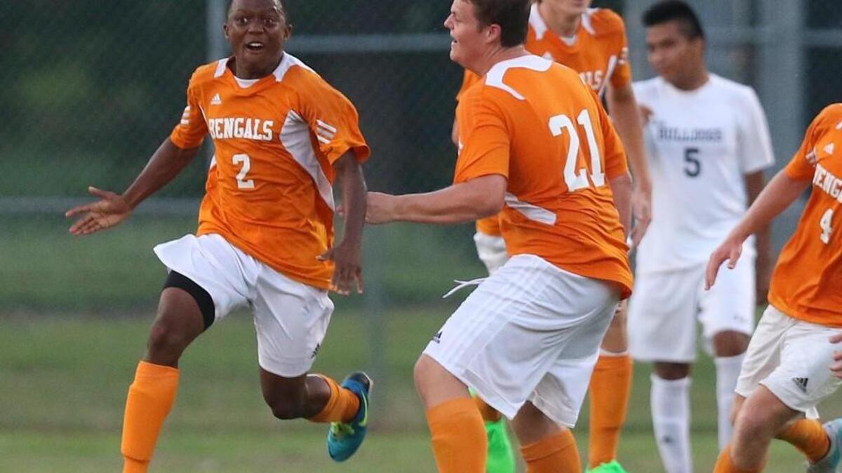 
Fuquay Varina's Brandon Sylvester (2) celebrates with teammate Cole Slater (21) after scoring the go-ahead goal with just seconds left in the game. The Southeast Raleigh Bulldogs played the Fuquay-Varina Bengals at Southeast Raleigh High School in Raleigh, N.C. on Tuesday, August 25, 2015. Fuquay-Varina won 2-1.
