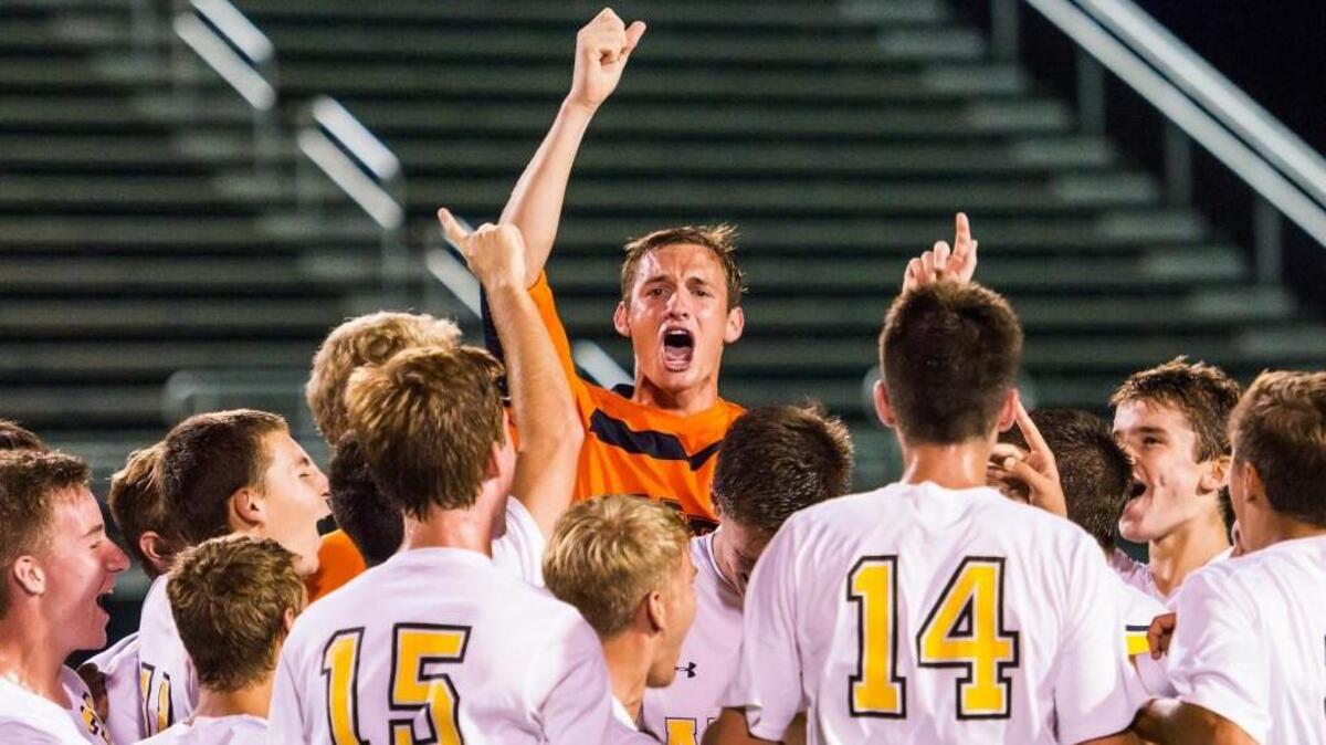 
Apex’s Corey Vodicka (25) is surrounded by teammates as they celebrate during a soccer game against Cardinal Gibbons on Saturday, September 19, 2015 in Raleigh, N.C. Apex Cougars won 3-0.
