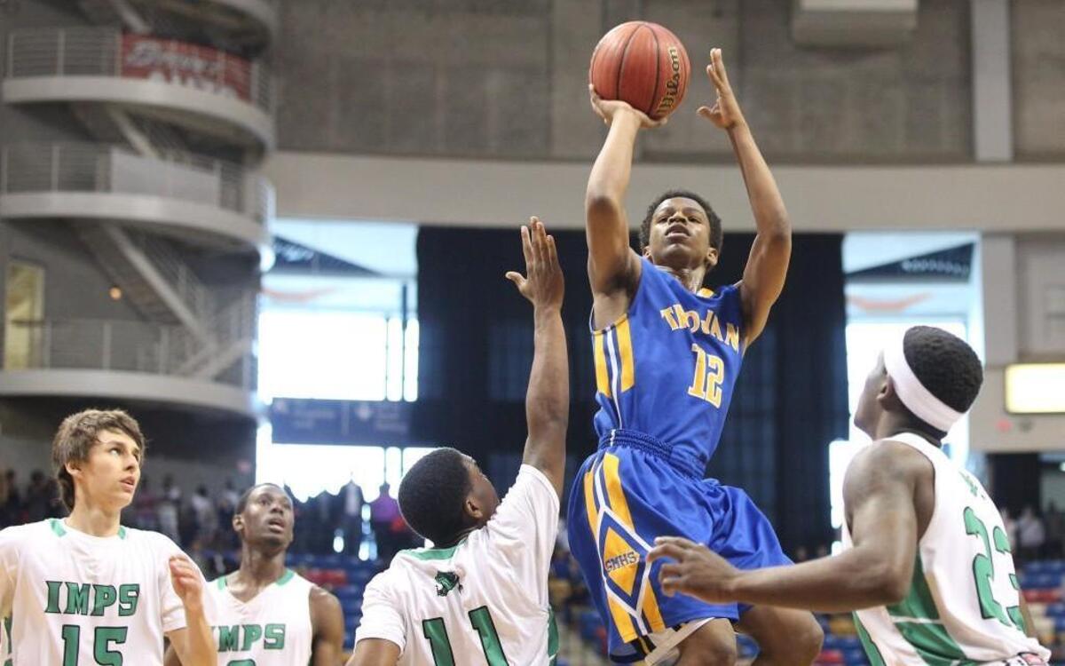 Garner's Thomas Allen (12) shoots over the top of Cary's Darrion Burnett (11) during the in the 4A Eastern High School Boys Regional Championship Game.
