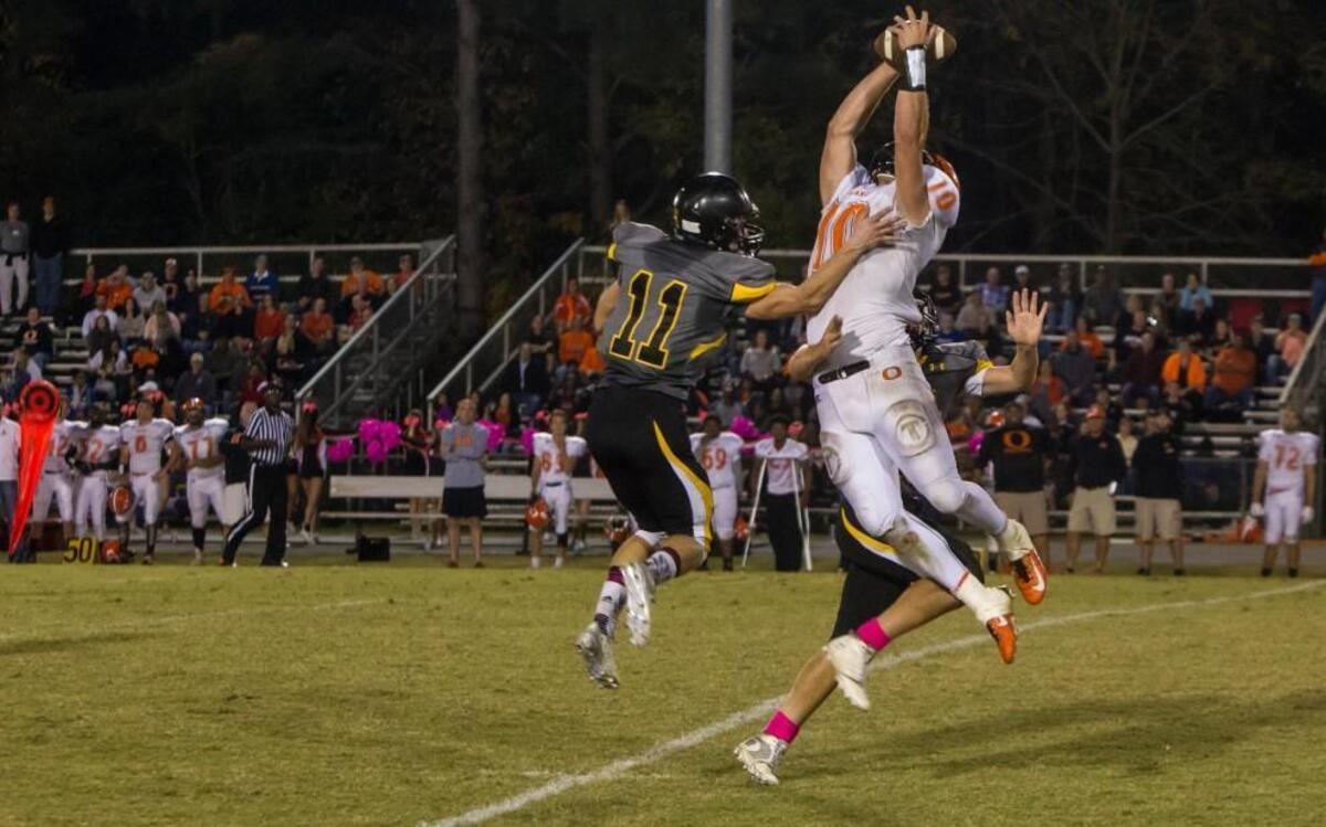 Bryse Wilson (10) of Orange goes high to make a catch between Tiger defenders Connor Korfas (11) and Ben Gleiter (obscured). Orange won Friday’s Big 8 football game at Chapel Hill, 40-19.