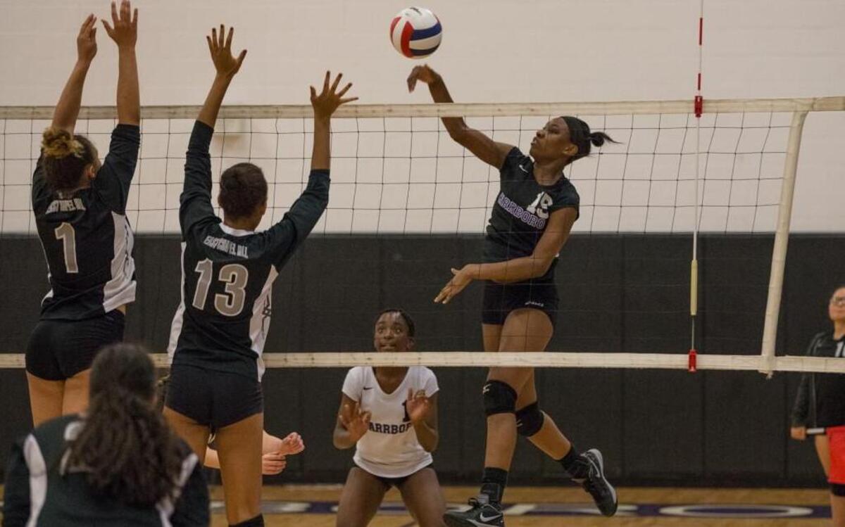 Destiny Cox (15) tries for a point against the defense of East Chapel Hill’s Zoe Dinkins (1) and Logan Pope (13) during Wednesday’s non-conference volleyball match.