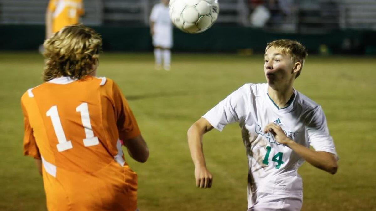
Cary’s Milosz Bis (14) brings in a high pass while being pressured by Fuquay's Caz Dabrowski (11) during Fuquay-Varina's soccer match at Cary on Thursday, October 8, 2015. Cary won the game 2-1.
