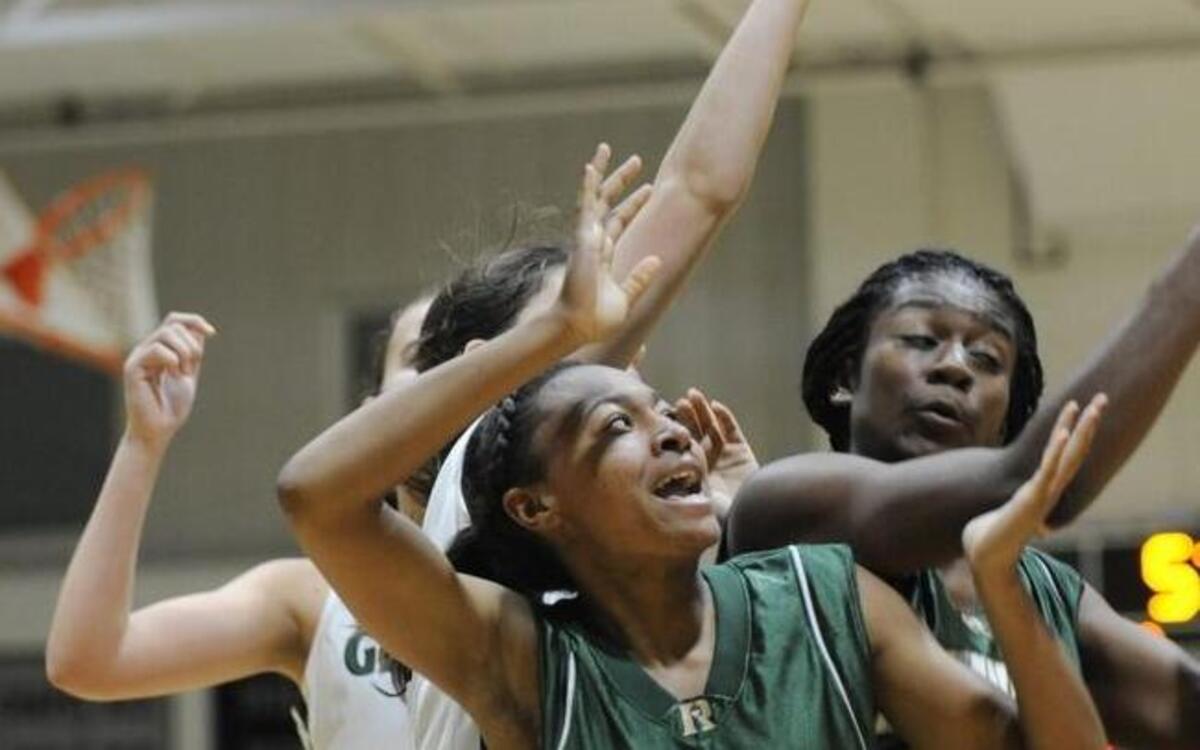 Ravenscroft's Madison Taylor (11) and Demi Washington (24) go after a rebound against Cardinal Gibbons in Raleigh, N.C. on Tuesday, December 8, 2015. Ravenscroft won 68-45.