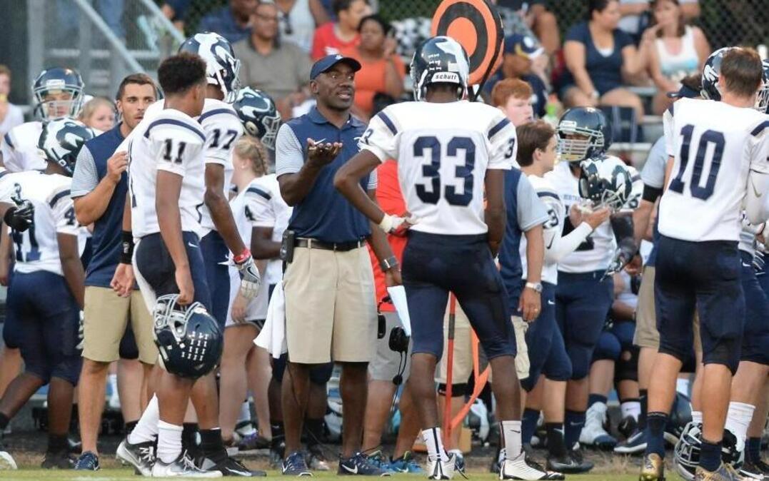 Dewayne Washington, center, head coach of Heritage, instructs his team during a timeout during their 32-17 victory over the Jordan Falcons in Durham on Friday, September 9, 2016.
