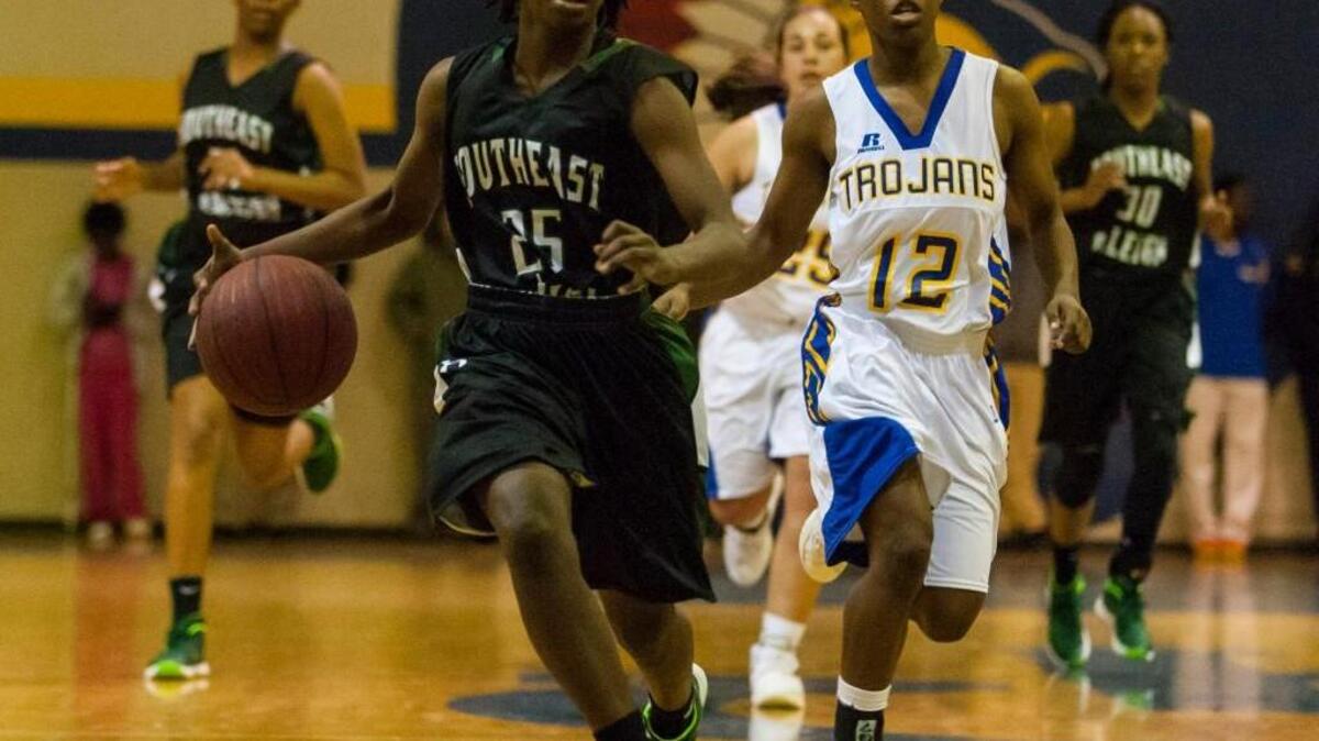 Southeast Raleigh’s Leikhiya McClenningham (25)makes her way to an open basket as Garner’s Gwen Creath (12) gives chase.