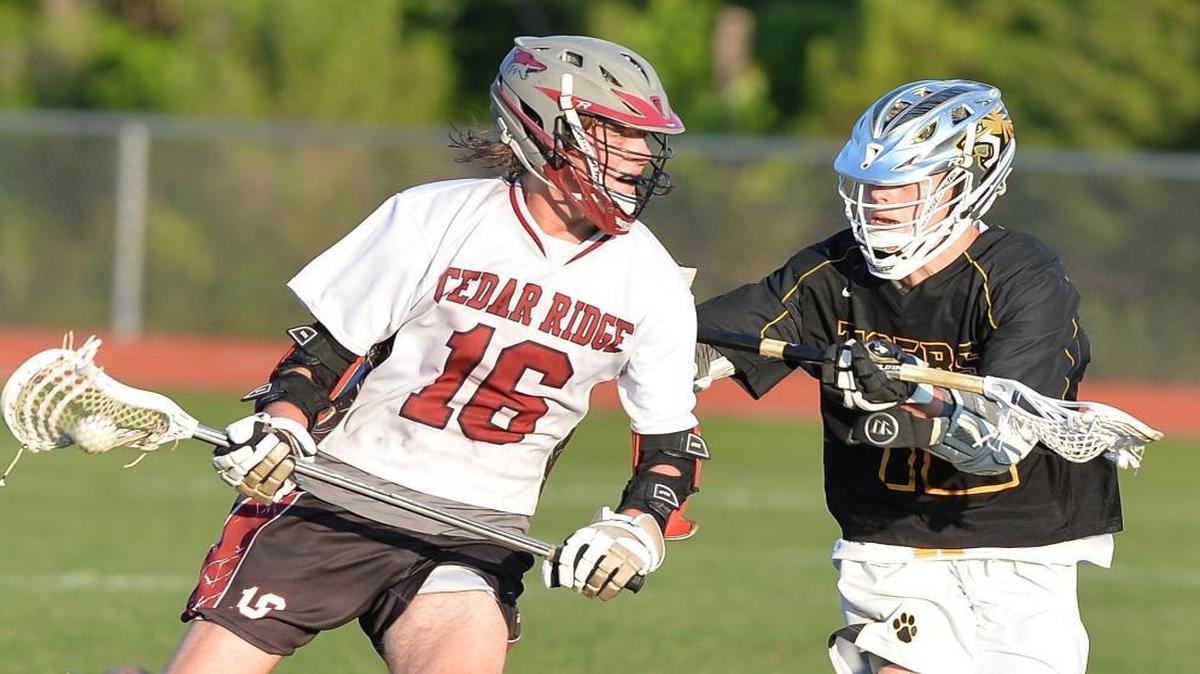 Carter Danku (16) of Cedar Ridge moves the ball against Sean Voelkel, right, of Chapel Hill. The Cedar Ridge Red Wolves played the Chapel Hill Tigers in a boys lacrosse game that took place in Hillsborough, N.C. on Tuesday, May 16 2017. Cedar Ridge won 11-8.