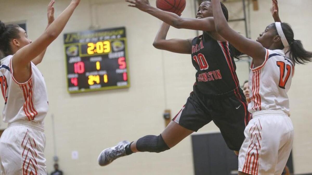 North Johnston’s Levossie Taylor (10) fights off North Pitt defenders Ta’shada Joseph (left) and Nyjanique Langley (right) as she puts up a one-handed shot.