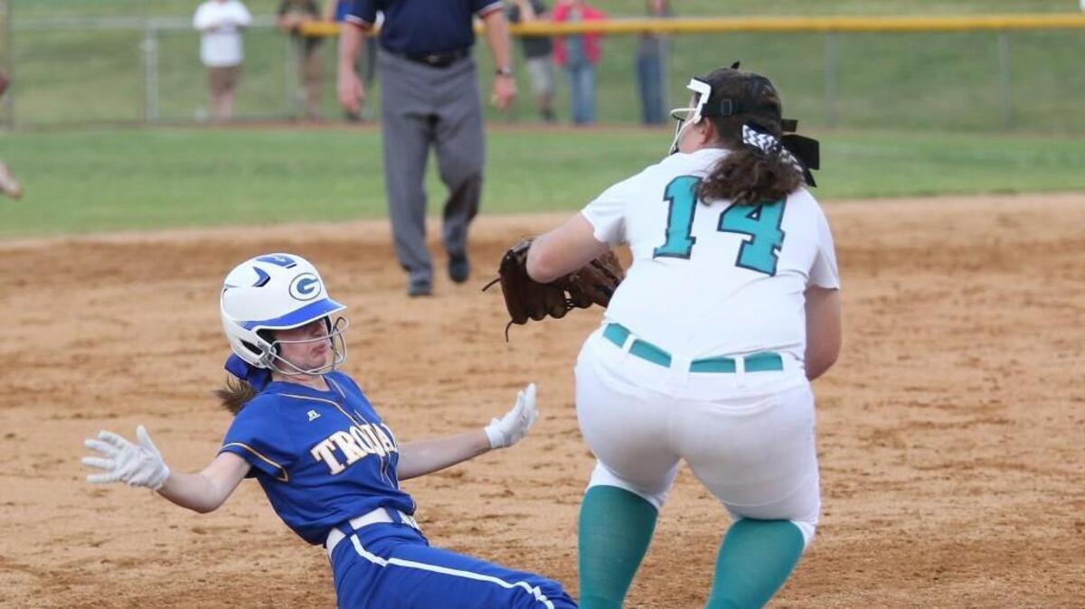 Garner's Sydney Jones (5) slides safely under West Johnston's Makayla Hackney (14) during the Garner Trojans High School softball game against the West Johnston Wildcats on April 29, 2016, in Benson, N..C. West Johnston won the game 11-2.