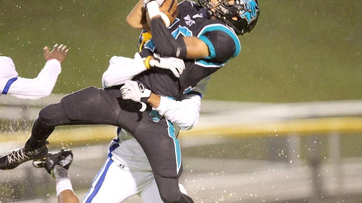 West Johnston’s Timare Robinson (10) hauls in a pass over East Wake's Davion Sutton (31) during Thursday's game.