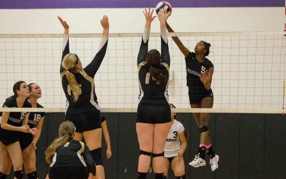 Carrboro’s Christine Alcox (5) goes for a kill shot Thursday night against Croatan as Jaguar teammates Fiona McGuire (15) and Sarah Montross (18) cheer her on. Carrboro won 3-0 to advance to the state quarterfinals of the NCHSAA 2A volleyball tournament.