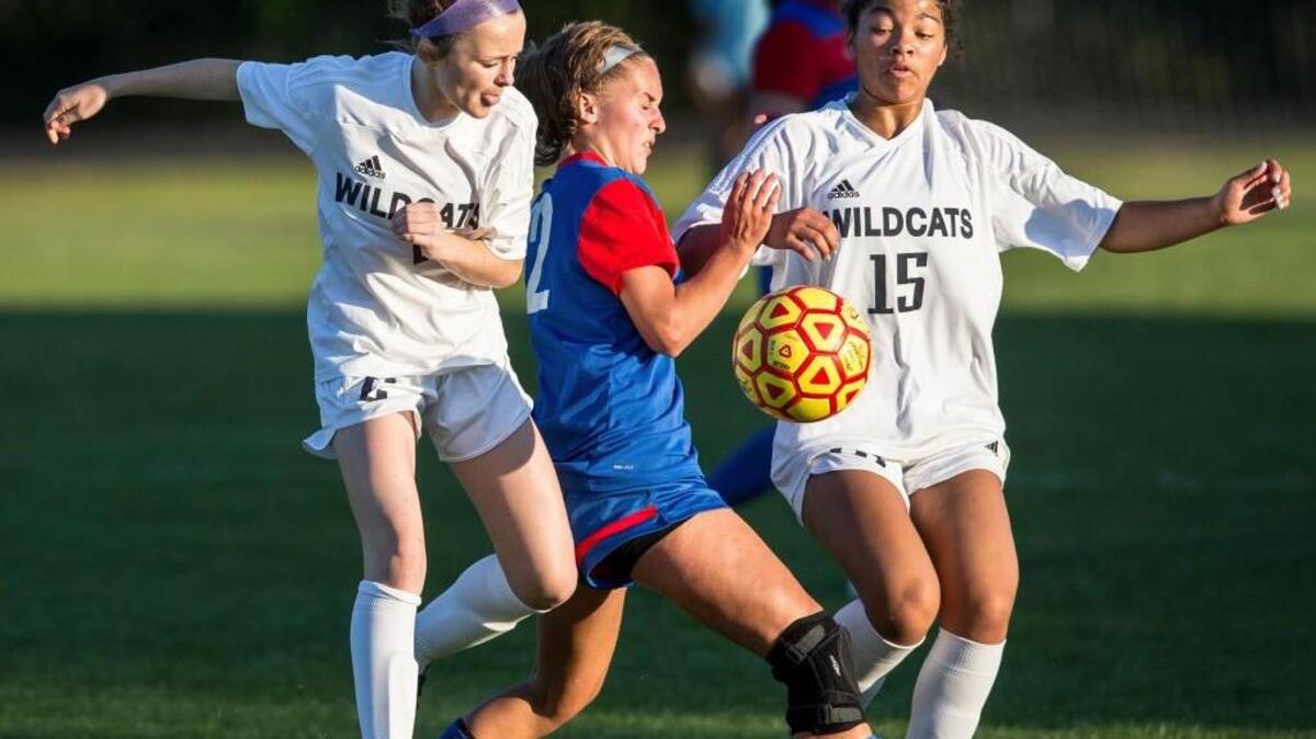 Millbrook’s Natasha Fisk (2) and Brianna Morris (15) fight for the ball against Wake Forest’s Olivia Speight, middle, during Monday’s game in Raleigh.