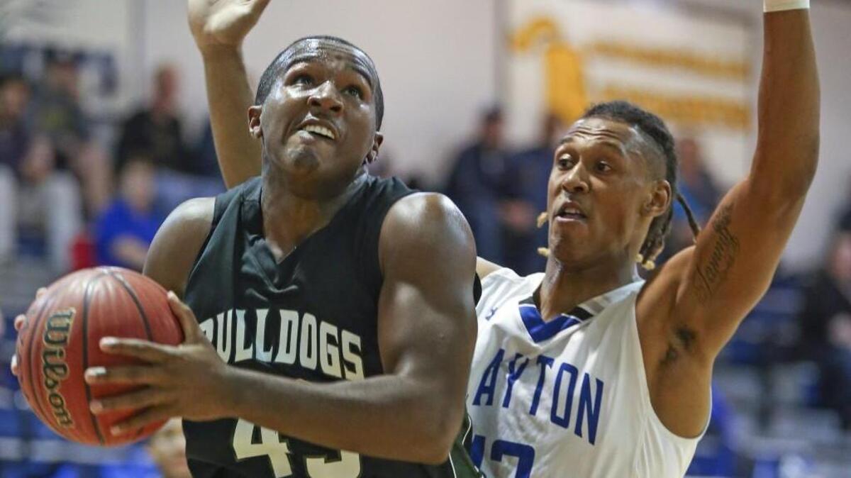 Southeast Raleigh's Sherman McLeod (45) gets inside position on Clayton's Devin Carter (12) as he goes in for a layup. Coverage from the prep basketball games between the Clayton Comets and the Southeast Raleigh Bulldogs played in Clayton, N.C. on Thursday, January 12, 2016. The Southeast Raleigh girls defeated Clayton 61-20 and the Southeast Raleigh boys defeated Clayton 56-50.