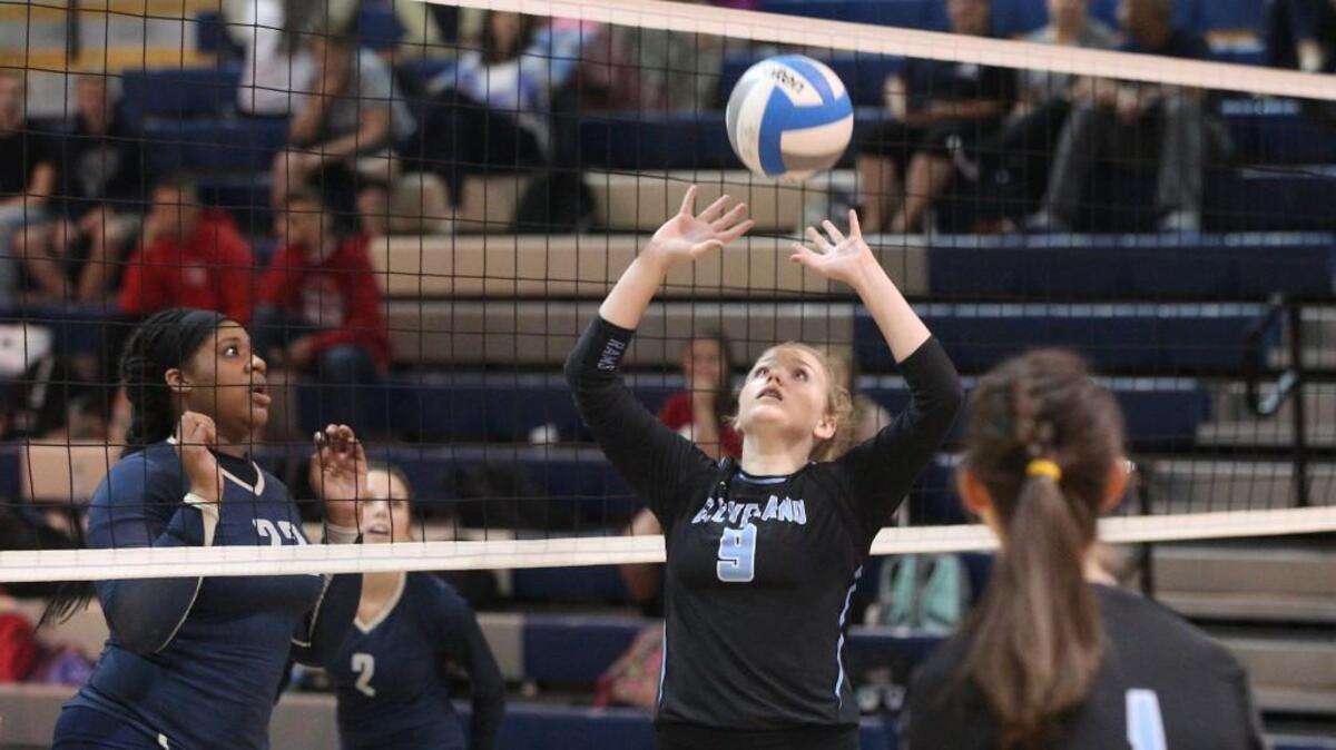 Cleveland's Jenna Myer (9) sets the ball up at the net as Smithfield-Selma's Mariah Godwin (22) looks on during the Clayton Comets High school Volleyball game with the Smithfield-Selma Spartans High School on September 20, 2016, in Clayton, N.C. Cleveland won 3-1.
