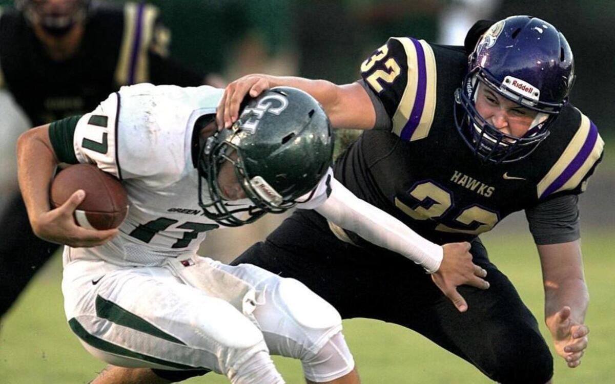 
Green Hope quarterback Tucker Burkinshaw (17) is sacked by Holly Spring's Hunter Chaney (32) in the first quarter on Friday, September 11, 2015 in Holly Springs, N.C.
