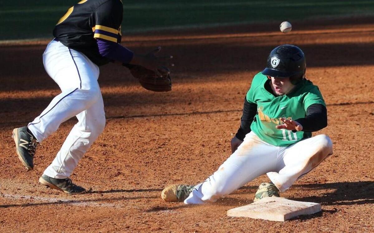 Cardinal Gibbons’ Gage Trenum (10) slides into third as Riverside's Varney Whitaker (15) goes to pick up the ball during the Riverside Pirates high school baseball game with the Cardinal Gibbons Crusaders high school , March 15, 2017, in Raleigh , N.C. Cardinal Gibbons won the game 6-1.