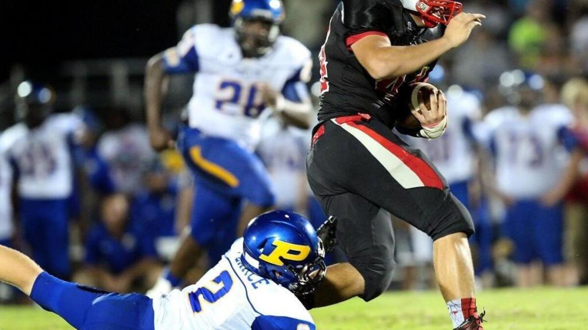 
North Johnston’s Benjamin Jaramillo (44) runs away from the arms of Princeton's Jarrett Pearce (2) during the North Johnston High School football game against Princeton High School, September 11,, 2015 in Kenly, N.C.North Johnston leads at the half 19-6.

