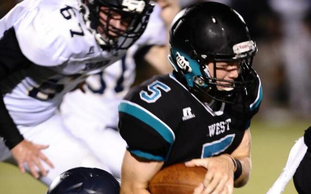 West Johnston's Noah Liles (5) is pulled down by Smithfield-Selma's Antonio McDonald (44) during West Johnston's football game against Smithfield_Selma. West Johnston wins 45-0, August 19, 2016 Benson, N.C. Damon Thomas. Thomas.