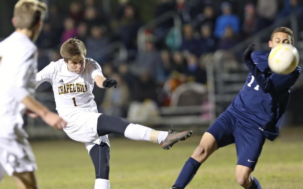 Chapel Hill's Sam Linker (1) fires a shot on goal past Southern Lee defender Miguel Hernandez (11). Coverage from the 4th Round of the NCHSAA Boys Soccer Tournament between the Chapel Hill Tigers and Southern Lee Cavaliers played in Chapel Hill, N.C. on Saturday, November 12, 2016. Chapel Hill advances with the 1-0 victory over Southern Lee.