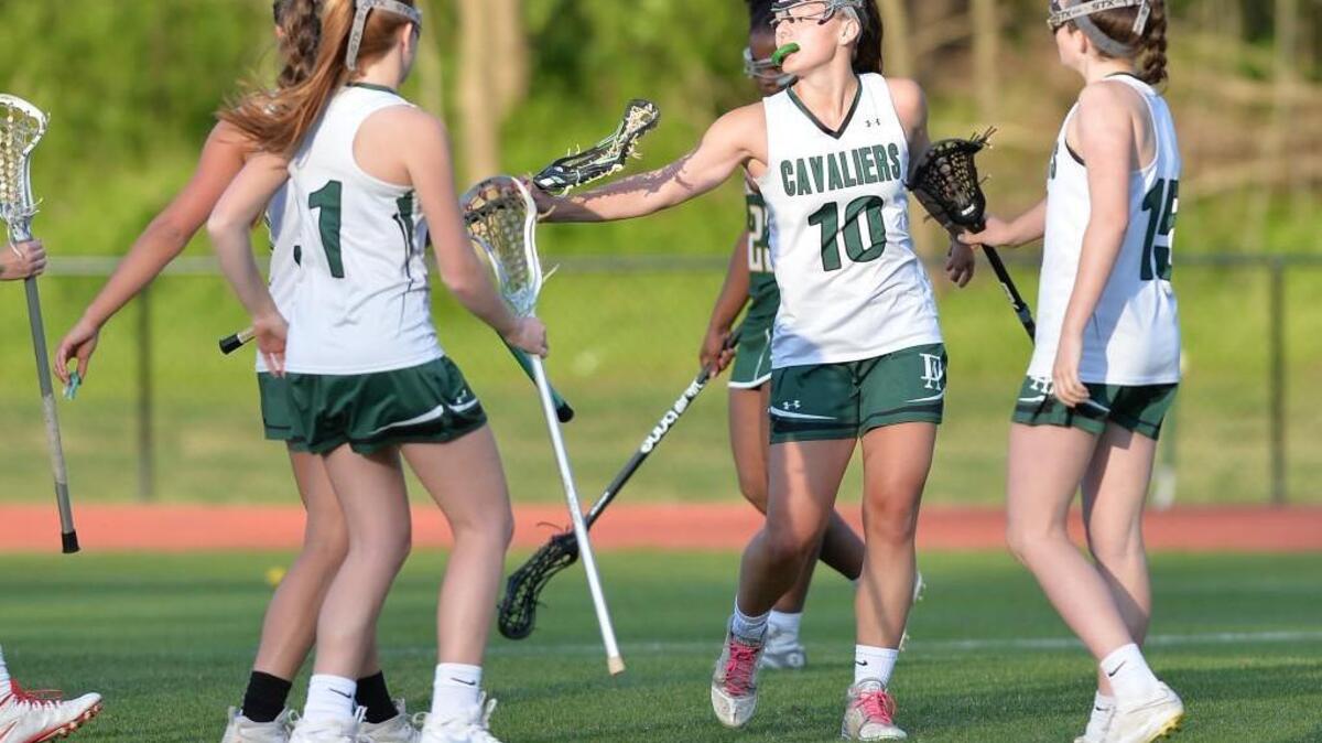 Madison Dunk (10) of Durham Academy celebrates along her teammates after scoring a goal for the Cavaliers. The Durham Academy Cavaliers played the Cardinal Gibbons Crusaders in a girls lacrosse game that took place in Durham, N.C. on Monday, April 11, 2016. Cardinal Gibbons won 18-8.