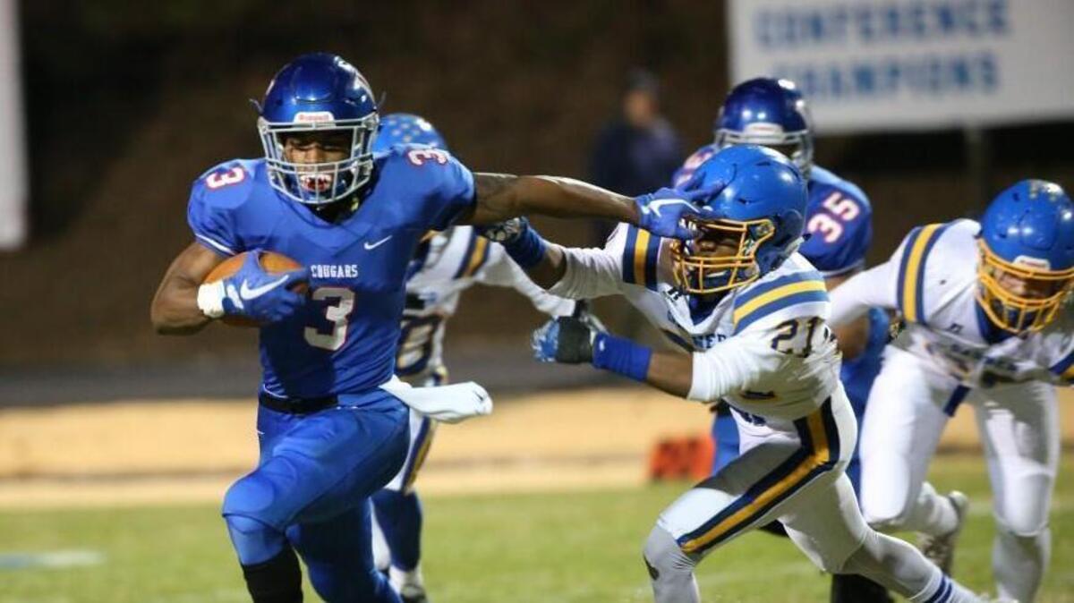 Wake Forest's Devon Lawrence (3) stiff arms Garner's Kilem Harris (21). The Garner Trojans visited the Wake Forest Cougars in the 4AA East final in the NCHSAA high school football playoffs on Dec. 1, 2017.