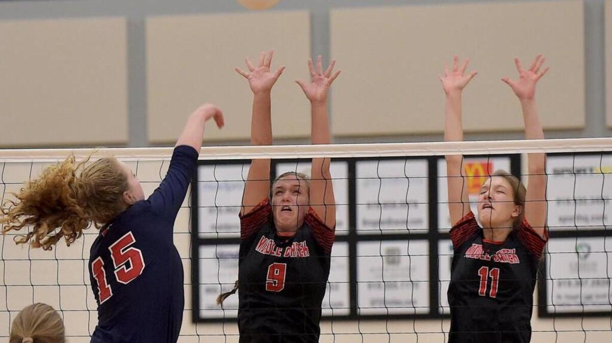 Apex Friendship's Madelyn Wilson (15) spikes the ball against the defense from Middle Creek's Elise Herring (9) and Courtney McNair (11). Apex Friendship took on Middle Creek in volleyball in Apex, N.C. on September 6, 2016. Middle Creek wins 3-1.