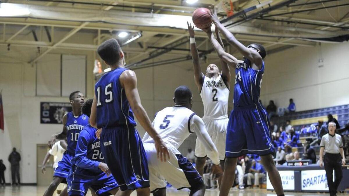 Smithfield-Selma’s Malik Frazier (2) and Fayetteville Westover’s Jalin Thorne (24) go to the air to battle for a rebound in Tuesday’s NCHSAA 3A boys basketball playoff game. Smithfield-Selma won, 60-56.