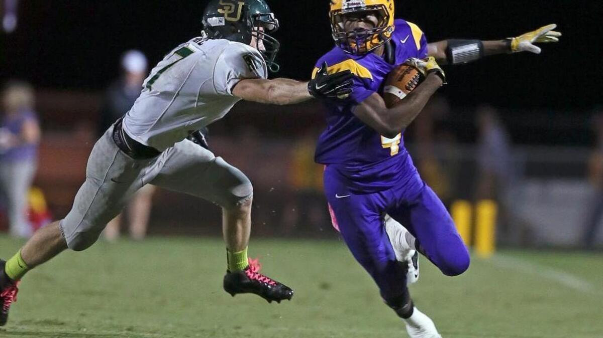 
South Johnston High’s Spencer Stone (17) gets a hand on Corinth Holders’ Jordan Neal but can’t stop a big gain down the sideline during their game in Wendell, N.C. on Friday, Oct. 17, 2014.
