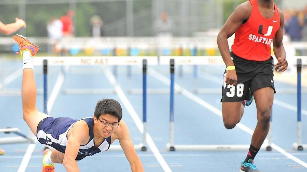 Raleigh Charter's Enoch Cheung dives for the finish line ahead of Union's Marcus Highsmith in their heat of the 300m1A 300 meter hurdles. The NCHSAA held its 1A and 3A boys and girls state track & field championships at North Carolina A&T State University in Greensboro N.C. on May 20, 2016.