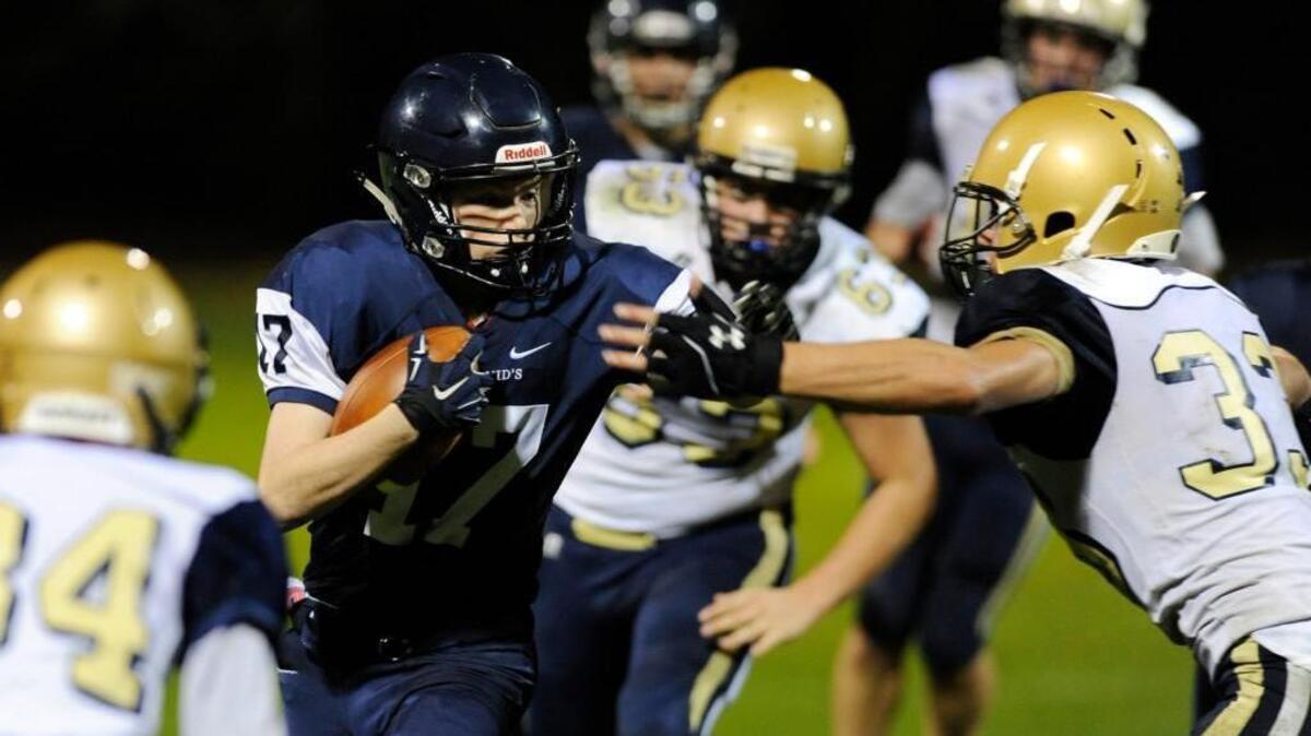 St. David's John Mac Feeney (17) stiff arms Cary Christian's Bryan Hellman (33) in Raleigh, N.C. on Friday, November 6, 2015. St. David's won 64-24.