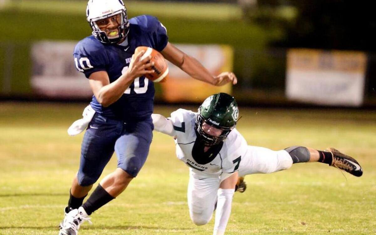 
Chauncey Caldwell (10) of Hillside avoids a tackle from Trevor Kirsch (7) of Cardinal Gibbons to gain yards for the Hornets. The Hillside Hornets played the Cardinal Gibbons Crusaders in Durham, N.C. on Friday, October 9, 2015. Hillside leads 28-8 at half time.
