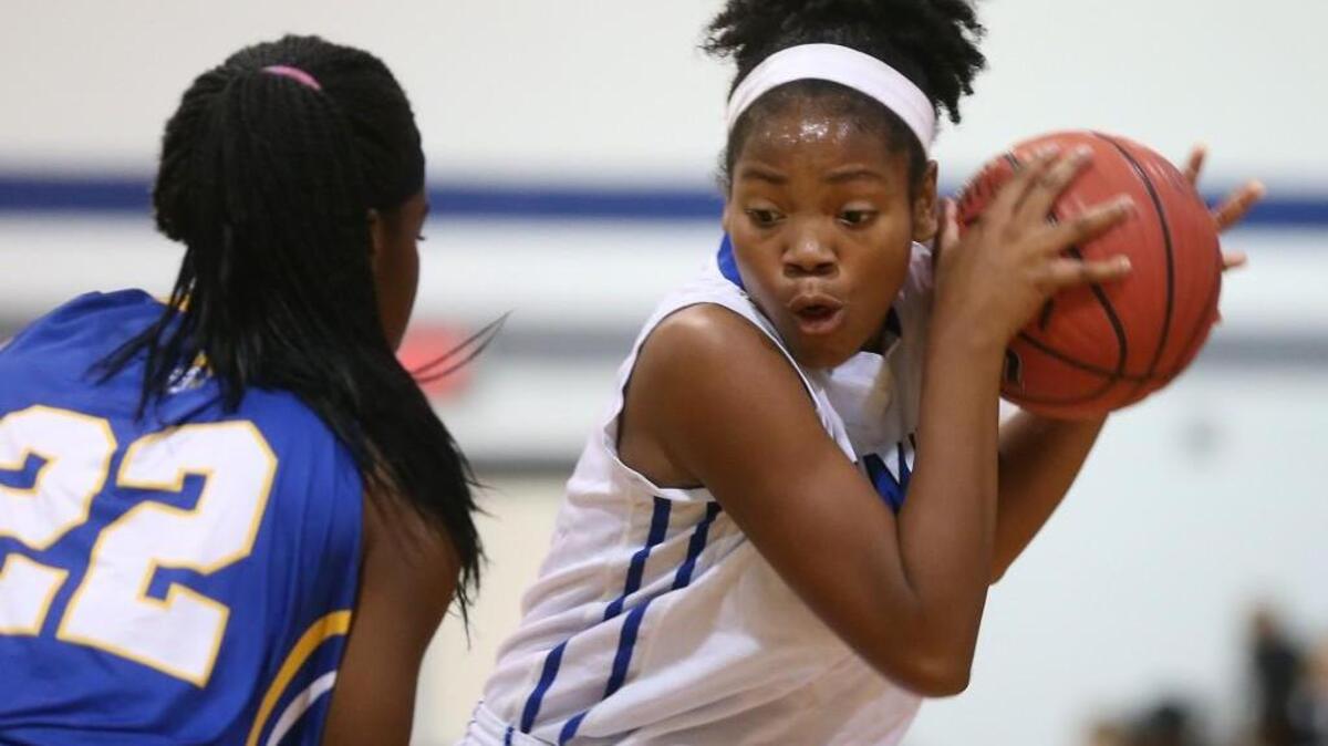 Clayton’s Asia Todd (5) protects the ball from East Wake’s Mikieja Covington (22).