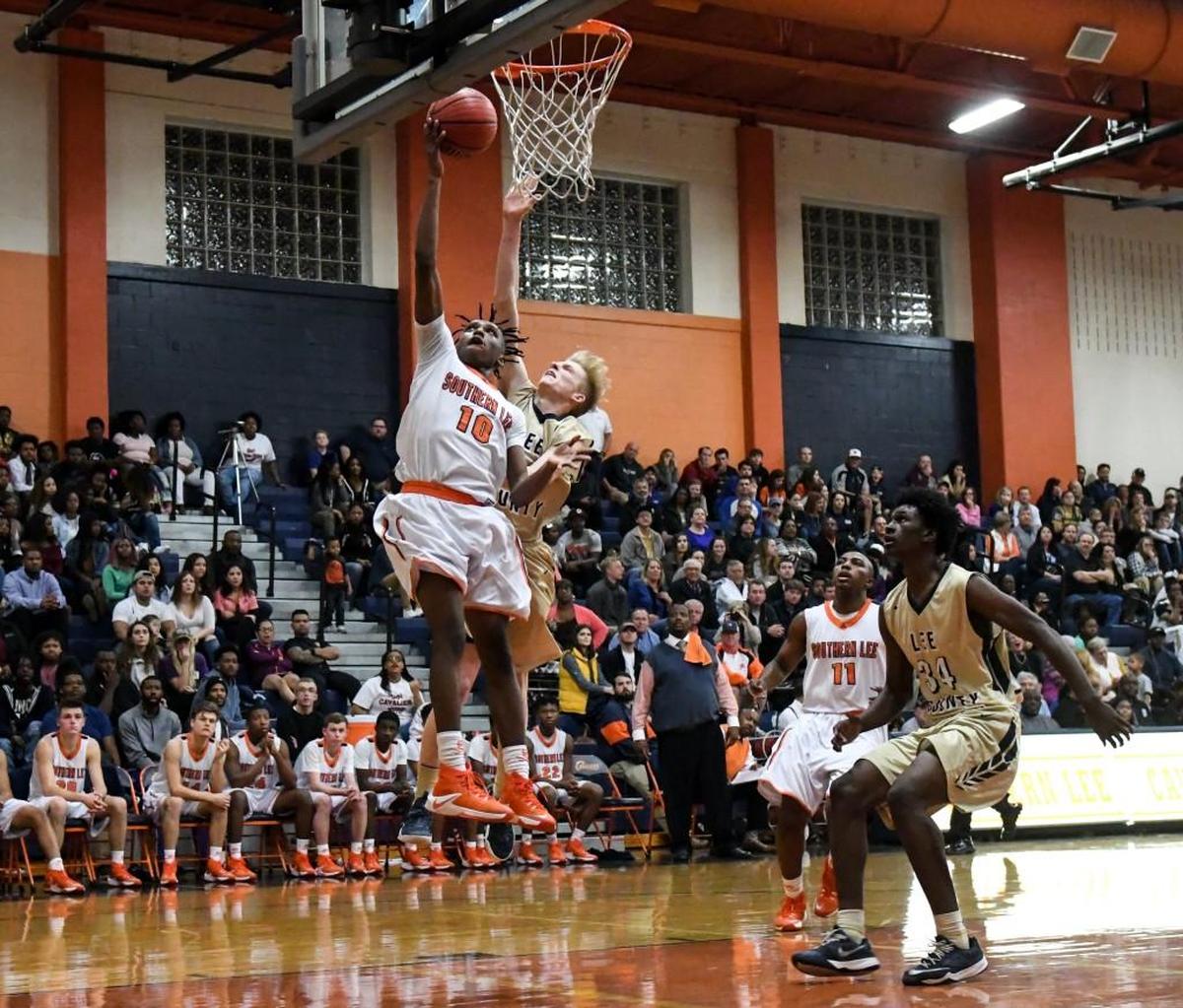 Southern Lee's Khalil Ridges (10) goes up high for lay up as Lee County's Trey North (24) tries to block shot during the Lee County's High School boys basketball game against Southern Lee High School in Sanford, N.C. on Wednesday, January 25, 2017. Southern Lee's boys won 55 to 36.