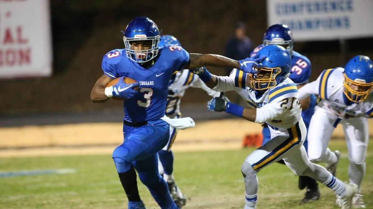Wake Forest's Devon Lawrence (3) stiff arms Garner's Kilem Harris (21). The Garner Trojans visited the Wake Forest Cougars in the 4AA East final in the NCHSAA high school football playoffs on Dec. 1, 2017.