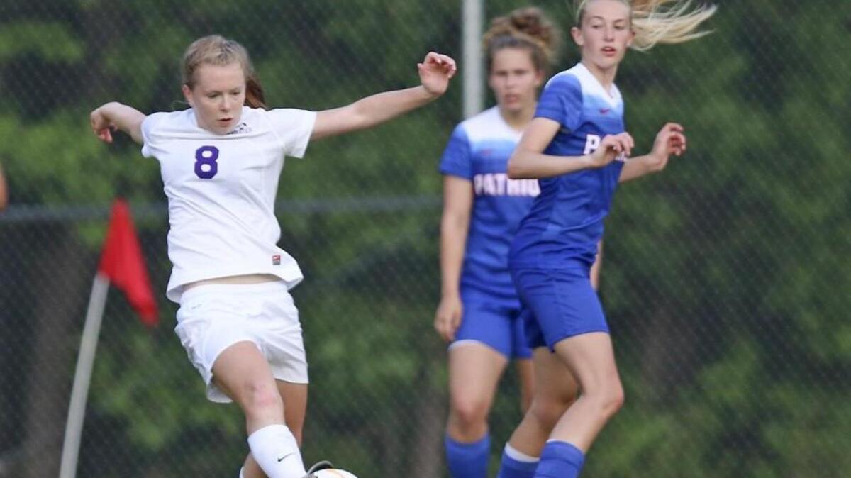 Corinth Holders’ Rylee Bays (8) sends the ball upfield after wrestling the ball away from West Carteret defender Kelisa Wardell (2).