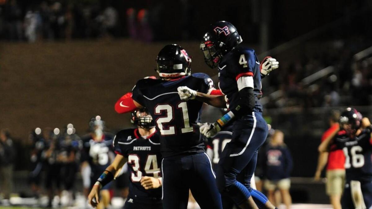 Apex Friendship’s Jacob Kelley (21) and Scott Sidney (4) celebrate a touchdown against Panther Creek during the football game, which was played on Friday, September 8, 2017 in Apex.