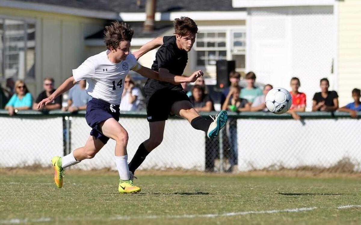 Greenfield's James Wells (5) kicks the ball as Wayne Country Day’s Jack Talton (14) defends during the North Carolina Independent Schools Athletic Association 1A Finals in the Greenfield School soccer game against Wayne Country Day School in Wilson, N.C. on Saturday, October 29, 2016.